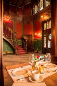 艾森纳赫Pension VILLA KLEINE WARTBURG的一间带桌子和楼梯的用餐室
