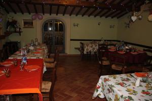 拉亚蒂科La Casanuova的一间带桌椅和红色桌布的用餐室