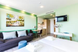 罗希姆诺Menta City Boutique Hotel的酒店客房,设有两张床和一张沙发