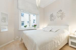 赫尔辛基Go欢乐之家公寓的白色的卧室设有白色的床和窗户。