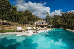 莫托文Villa Torrecorta的一个带2把躺椅的游泳池以及1栋房子