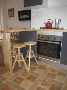 EsteponaHeart of Estepona的厨房配有柜台、两张凳子和烤箱。