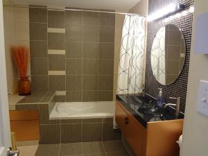 圣多纳特蒙卡尔姆Hotel Saint-Donat的带浴缸、水槽和镜子的浴室