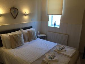 Dersingham羽毛旅馆的卧室配有白色床和毛巾
