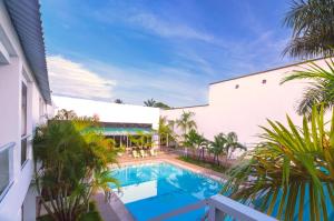 莱蒂西亚怀拉套房酒店的棕榈树建筑旁边的游泳池