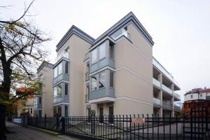 波兹南Very Berry - Orzeszkowej 10 - MTP Apartment, parking, balcony, check in 24h的前面有黑色栅栏的白色建筑