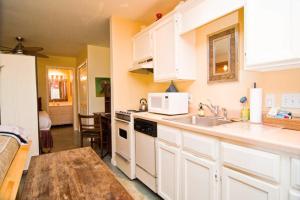 奥斯汀Barton Hills Condo的厨房配有白色橱柜、水槽和桌子