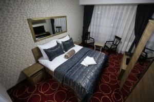 普里什蒂纳Hotel Pejton的酒店客房,配有床和镜子