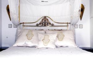 得土安里亚德柯米萨庭院旅馆的一张带华丽床头板和枕头的床