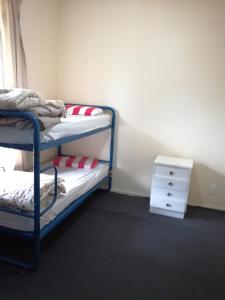 Raurimu SpiralSlalom Lodge的一间卧室设有两张双层床和床头柜。