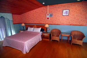 台南百威汽车旅馆的一间卧室配有一张床和两张桌子及椅子