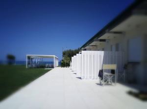 朱利亚诺瓦Agriturismo Frontemare的白色建筑旁边的白色围栏