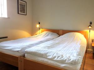 凯特明讷Ferielejlighed på Rødkærgård的一间卧室配有一张带白色床单和两盏灯的床。