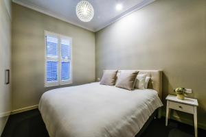 芒特甘比尔Aloha Central Luxury Apartments的卧室配有一张大白色床和窗户
