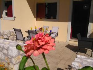 米克罗斯雅洛斯Mikros Gialos Apartments的一张桌子前的粉红色花朵,椅子