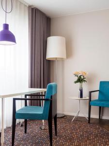 隆德Finn Apartments的一间带桌子和两把蓝色椅子的用餐室