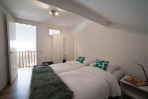 Helvoirt德荣斯乌尔特公寓的一张白色的床,位于一个配有沙发的房间