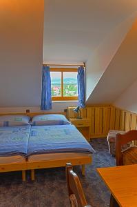 捷克克鲁姆洛夫格瑞塔民宿酒店的一间卧室设有两张床、一张桌子和一个窗口