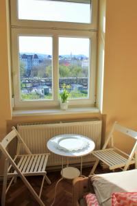 布达佩斯Lidi Guesthouse的客房设有桌子、两把椅子和窗户。