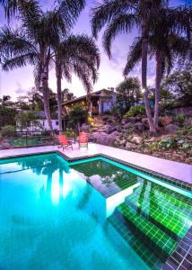 普腊亚罗萨玫瑰花蕾旅馆的一座棕榈树游泳池和一座房子