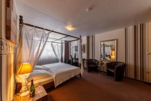 施托尔贝格City Hotel Stolberg的酒店客房带床、椅子和镜子