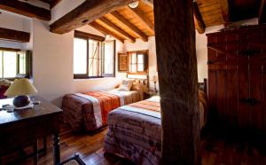 TurzaCasa de Montaña La Solana de Turza的一间带两张床的卧室,位于木天花板的房间