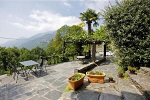 卡尼洛瑞维拉Rustico La Vigna的庭院配有桌椅和植物