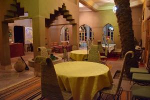 姆哈米德Hotel Carrefour des Nomades的一间设有两张桌子和椅子的房间,树木