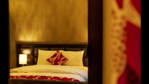 安曼沙姆斯艾尔韦布德公寓式酒店的一间卧室配有红色和白色枕头的床