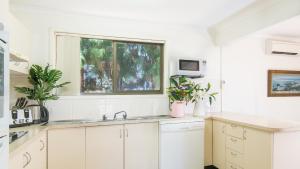 文森提亚德利福德海滨度假屋@文森提亚的白色的厨房设有水槽和窗户