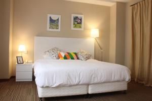 新加坡Alocassia Serviced Apartments的卧室配有一张带两个枕头的大白色床