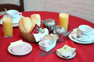 里约热内卢Shelton Hotel的红色桌子,上面有一篮面包和两根蜡烛