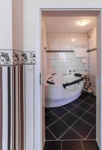 施托尔贝格City Hotel Stolberg的一间带浴缸的浴室,位于一间铺有瓷砖地板的客房