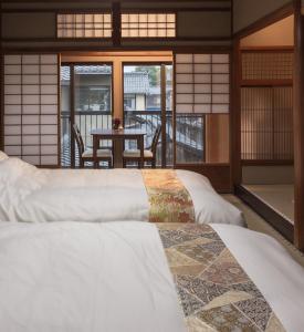 京都丸子旅馆京都酒店的客房设有两张床和一个带桌子的阳台
