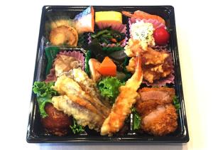 旭川旭川特伦德酒店的黑盘食物,包括海鲜和蔬菜