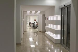 奇尔奥马里纳Hotel Miramare的走廊设有白色的墙壁和桌椅