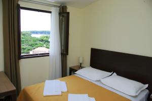 普利兹巴帕里斯卡帕克度假酒店的一间卧室配有带两个枕头的床和窗户