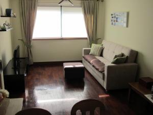 Senhora da HoraComfortable & central apartment的带沙发和窗户的客厅