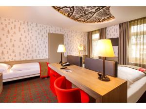 苏黎世瑞士之夜法斯宾德酒店的酒店客房配有书桌和床。
