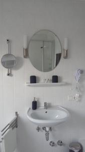 BergenHotel Piano的白色的浴室设有水槽和镜子