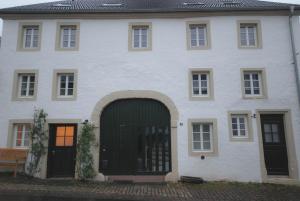 杜德尔多夫Living-in-History: Historischer Charme und Design的一座带绿门的大型白色房屋