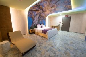 金山区鼎帅温泉汽车旅馆 的酒店客房设有一张床,墙上挂有绘画作品