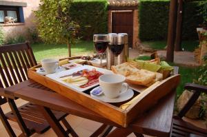 Camañas卡莱特里亚乡村民宿的一张木桌,上面放着一盘食物和两杯葡萄酒