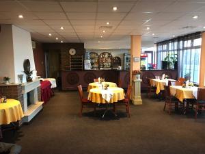 索非亚康瑟尔酒店的用餐室配有桌椅和黄色桌布