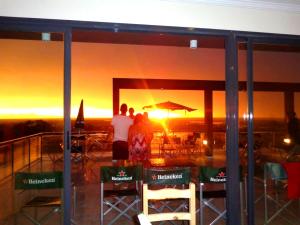 维多利亚Rio Manso Apartamentos的一群人透过窗户观看日落
