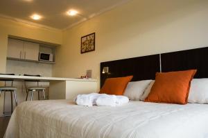 维多利亚Rio Manso Apartamentos的一间卧室配有一张大床和毛巾