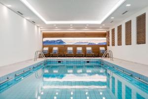 费尔德基兴鲍尔餐厅酒店的一个带椅子的酒店游泳池和一个室内游泳池