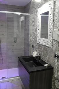 奇尔奥马里纳Hotel Miramare的浴室配有盥洗盆和带镜子的淋浴