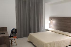 奇尔奥马里纳Hotel Miramare的一间卧室配有一张床、一张桌子和一把椅子
