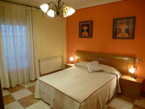 拉伊鲁埃拉Casa Limas的一间卧室设有橙色的墙壁、一张床和两盏灯。